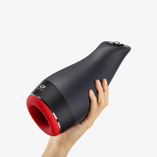 Hand holding the OTOUCH male masturbator, showing the product’s exterior design.